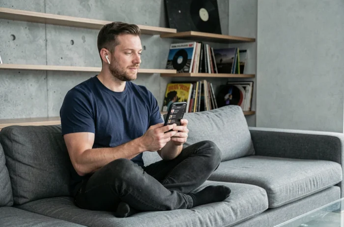 Homme écoutant de la musique sur smartphone avec une playlist créée depuis YouTube via un convertisseur MP3
